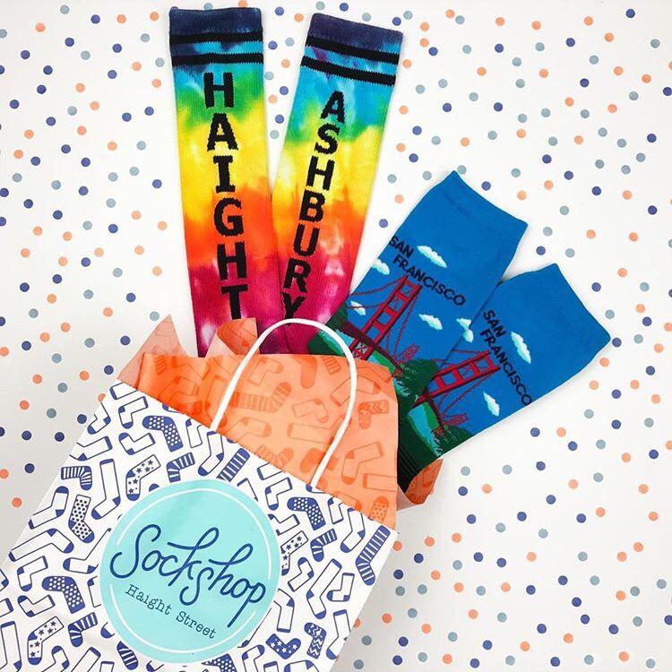 Brightly colored socks coming out of patterned gift bag with tissue paper